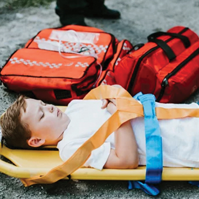 Pediatric patient immobilized and transported on a stretcher.