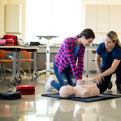 AED certification class with student using a manikin.